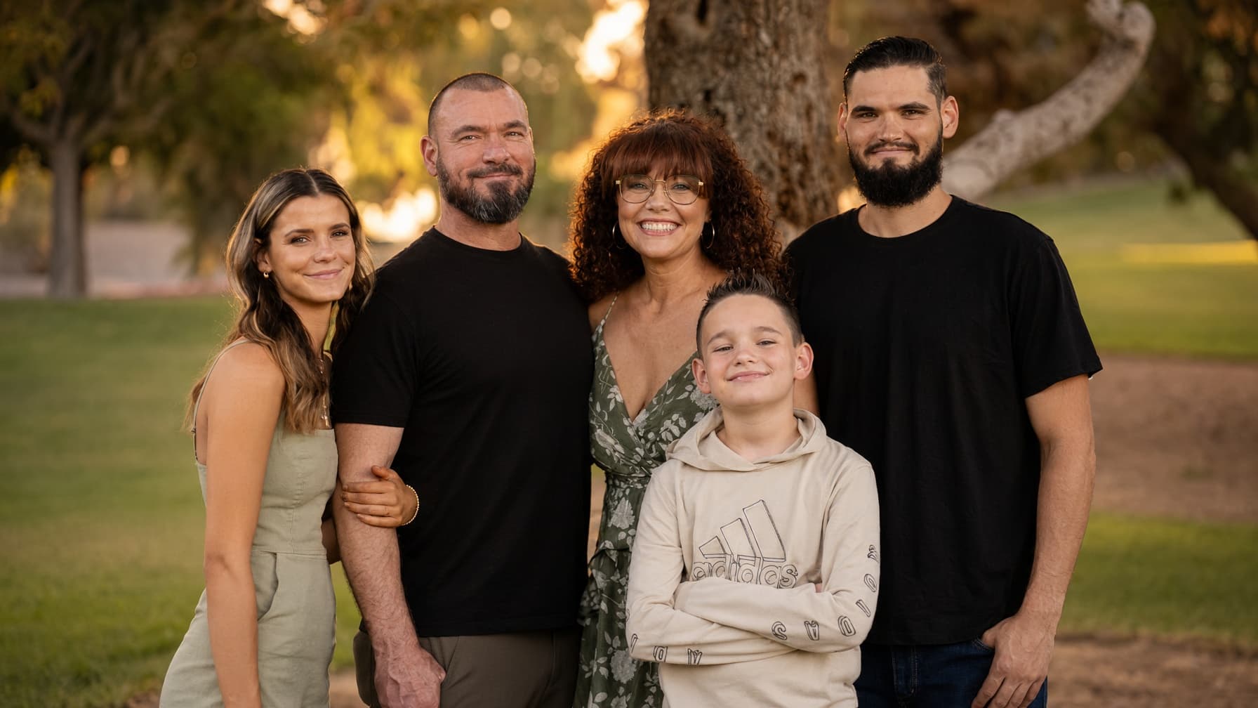 Kelsey with her people, outdoors under a tree