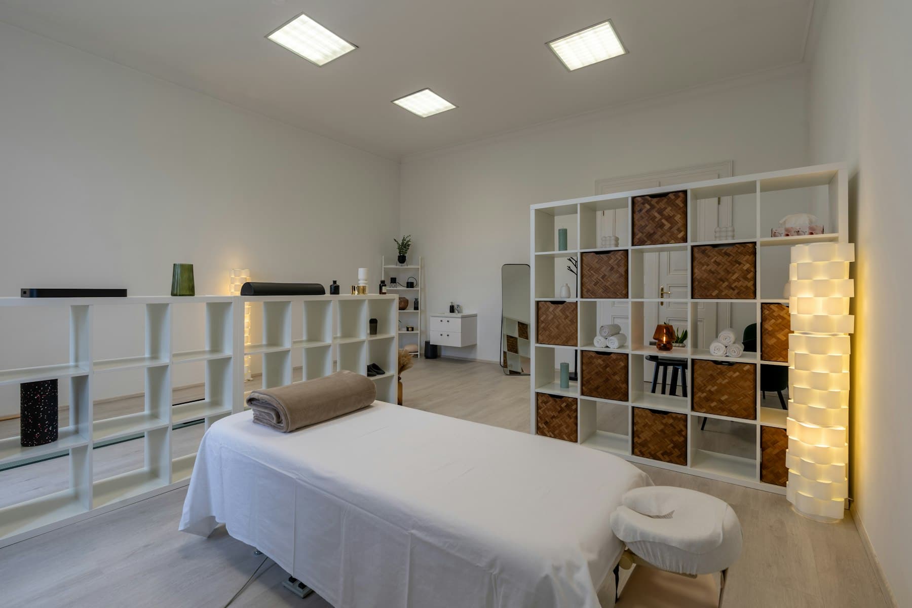 A quiet treatment room with a linen-covered table and a rolled towel, ready for an appointment